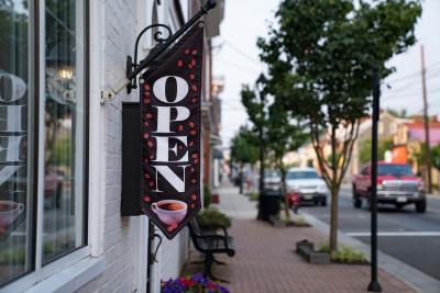 Downtown Congress street along the outside of the Strayer House building showcasing an open for business sign