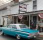 Photo of the front of Simple Tymes showing an antique car, and the front porch area